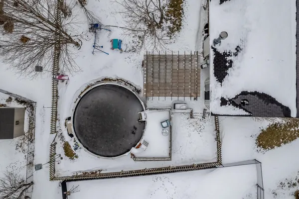 a front view of a house with a yard covered in snow