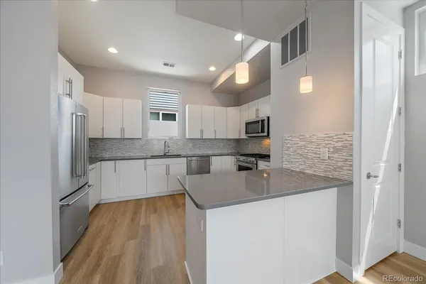 a kitchen with stainless steel appliances granite countertop a sink and refrigerator