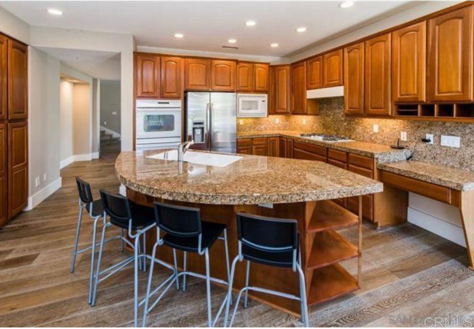 1317 Caminito Balada La Jolla, CA 92037 - Photo 7 of 16 a kitchen with granite countertop kitchen island stainless steel appliances a sink table and chairs