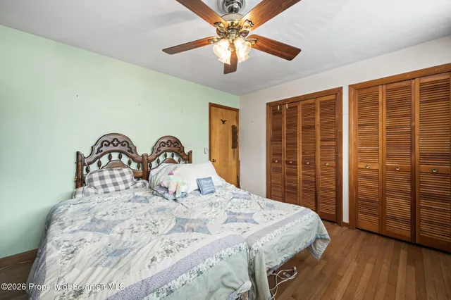 a bedroom with a bed and a window with wooden floor