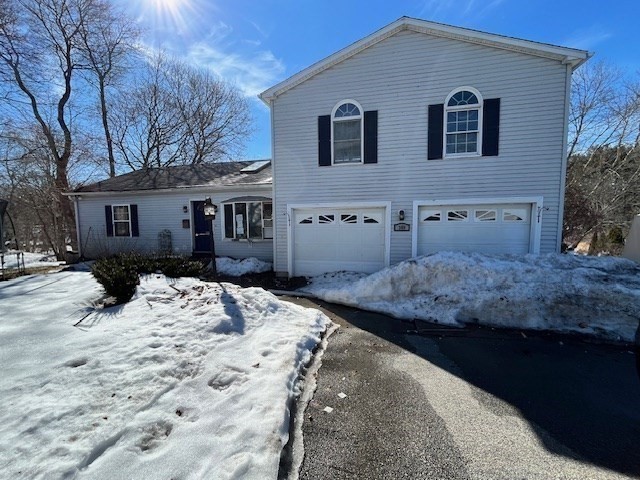 a front view of a house with a yard covered in snow