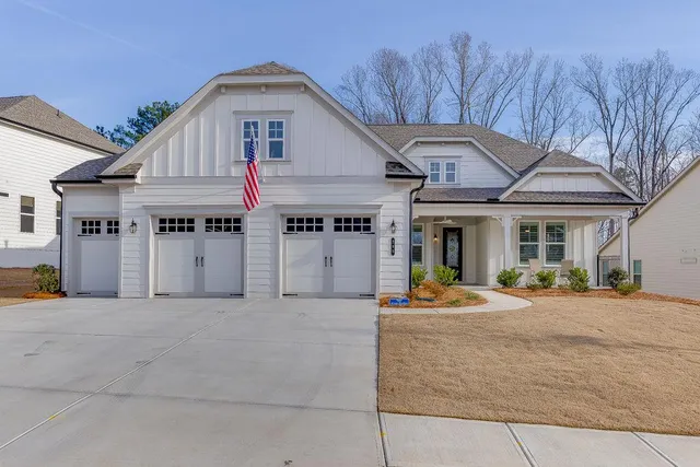 a front view of a house with outdoor seating and a lots of windows in it