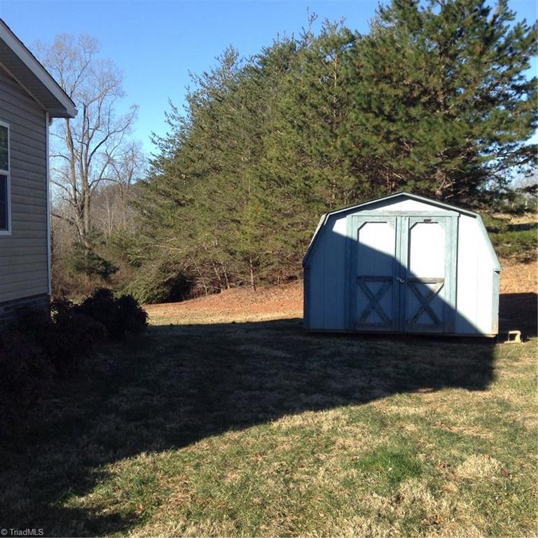 2716 Prison Camp Road Dobson, NC 27017 - Photo 7 of 21 Side yard with storage unit that conveys