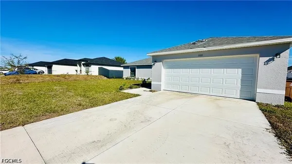 a view of a house with a yard and garage