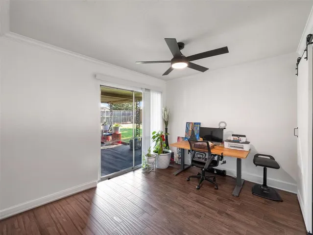 a view of a workspace with wooden floor and a window