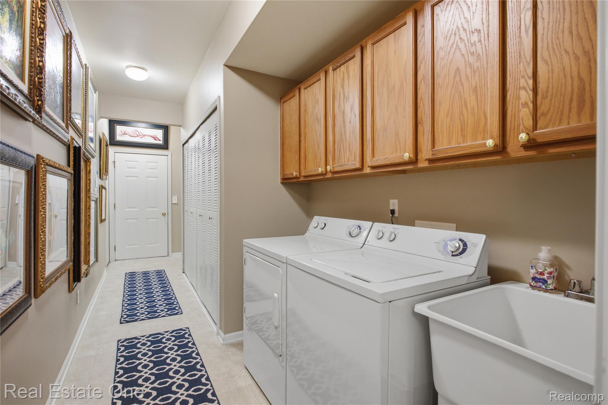 1828 Flagstone Circle, Unit 40 Rochester, MI 48307 - Photo 5 of 22 Dedicated laundry area with a utility sink and upper wood cabinetry