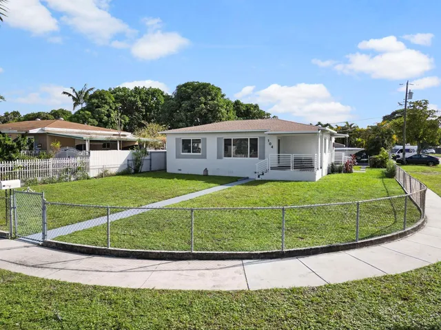 a view of a house with a small yard and sitting area