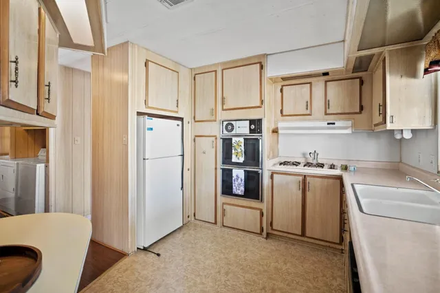 a kitchen with stainless steel appliances a refrigerator sink and cabinets