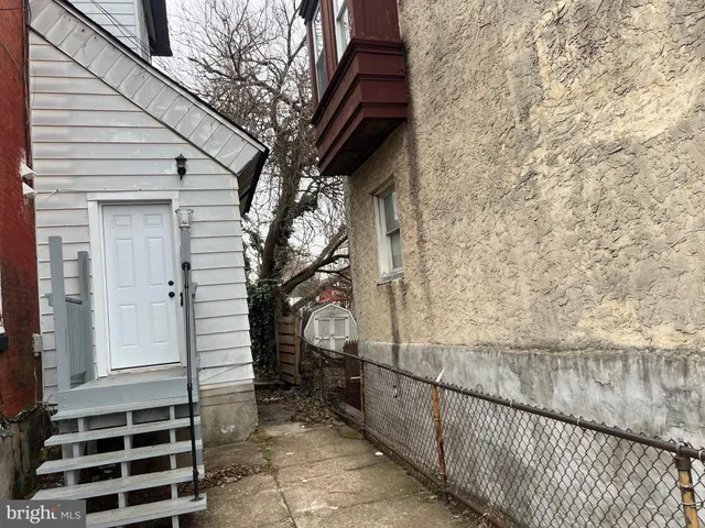 a view of a pathway of a house with wooden fence