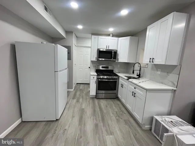 a kitchen with stainless steel appliances a refrigerator a sink a stove a microwave a sink a refrigerator and cabinets