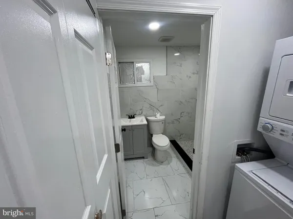 a bathroom with a granite countertop toilet and a shower