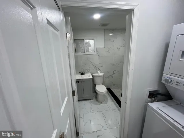 a bathroom with a granite countertop toilet and a shower