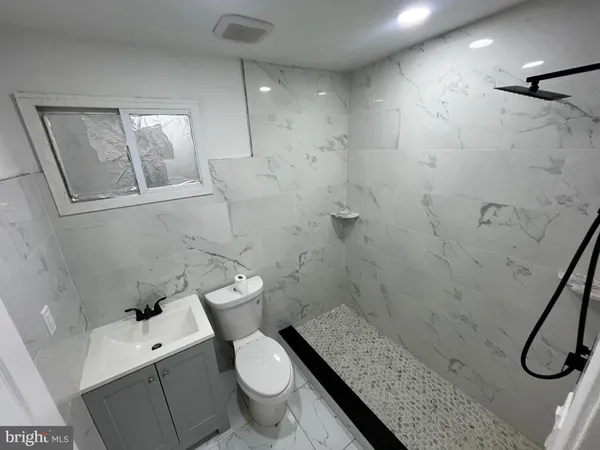 a bathroom with a granite countertop toilet sink and shower