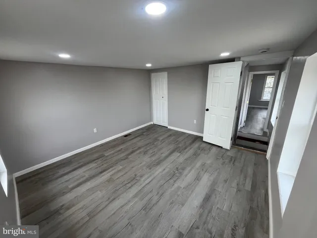 an empty room with wooden floor and entrance