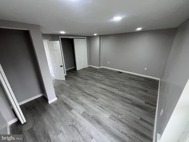 an empty room with wooden floor and entrance