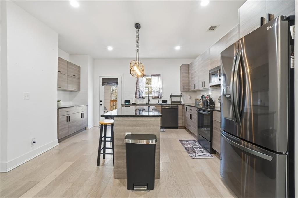 2281 Pryor Road Southwest Atlanta, GA 30315 - Photo 12 of 32 a kitchen with refrigerator a sink and chairs