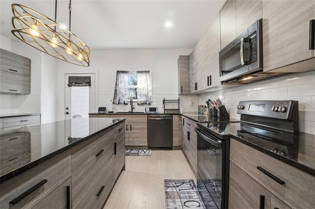 2281 Pryor Road Southwest Atlanta, GA 30315 - Photo 14 of 32 a kitchen with stainless steel appliances granite countertop a sink a stove and cabinets
