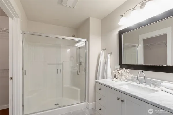 a bathroom with a shower sink vanity and mirror
