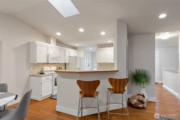 a kitchen with stainless steel appliances granite countertop a table and chairs in it