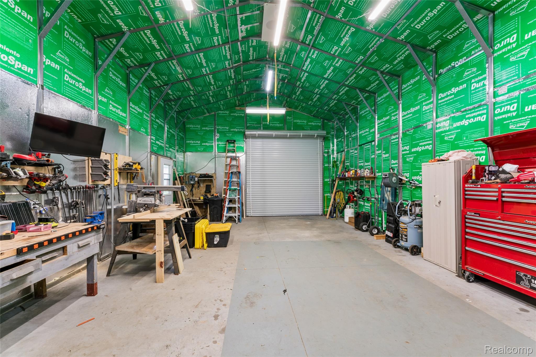 1336 West Hurd Road Clio, MI 48420 - Photo 35 of 43 Spacious workshop featuring a large rollup door, concrete flooring, and metal frame construction