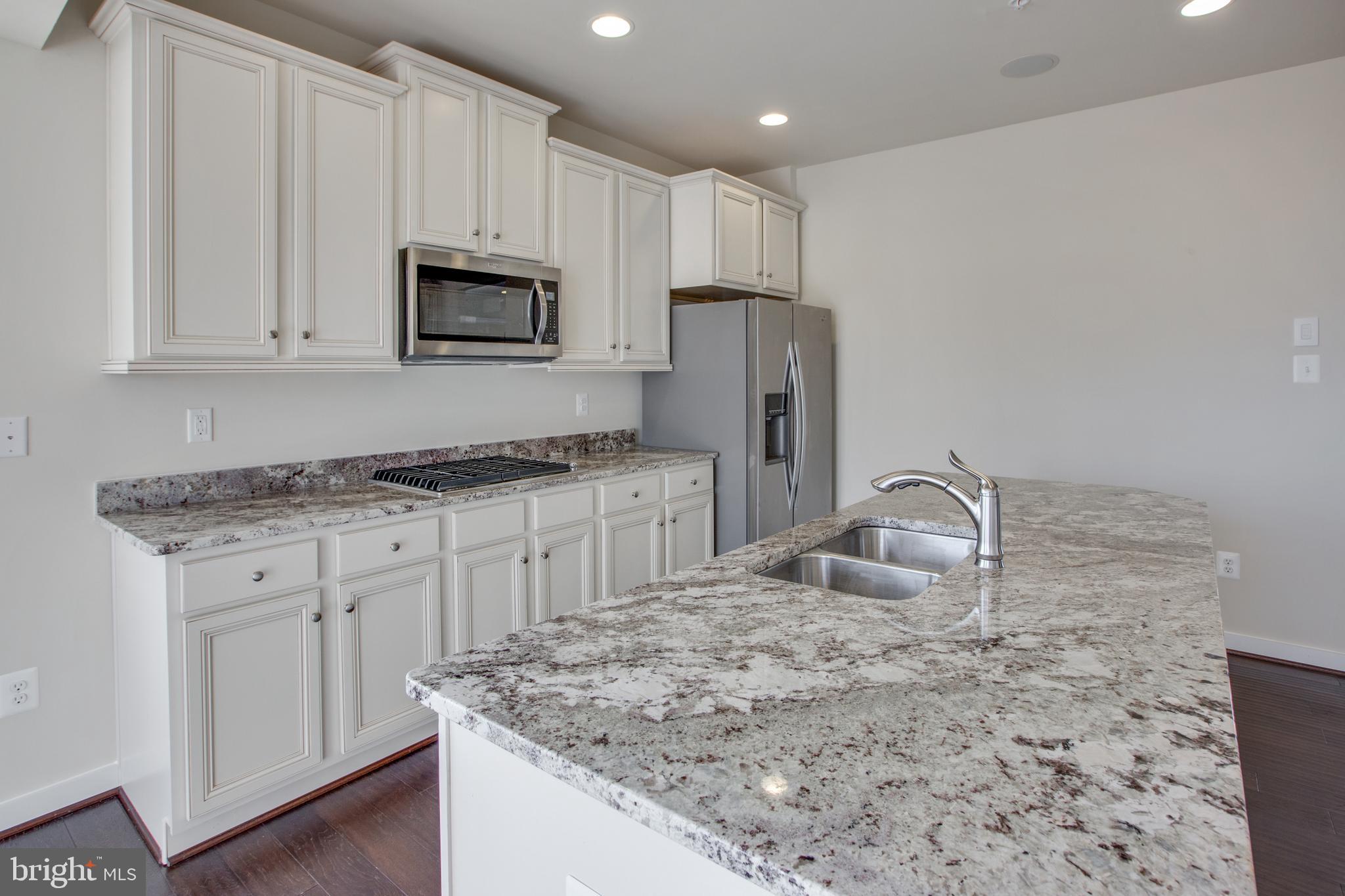 Tbb Tbb Stuart Street, Unit JEFFERSON Charles Town, WV 25414 - Photo 4 of 40 a kitchen with granite countertop white cabinets and stainless steel appliances