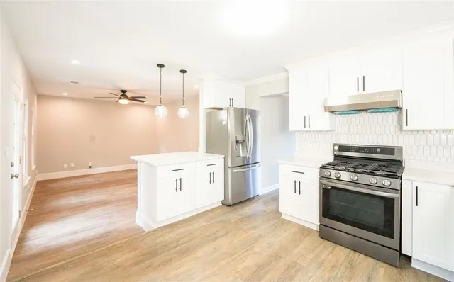 a kitchen with a stove top oven and refrigerator