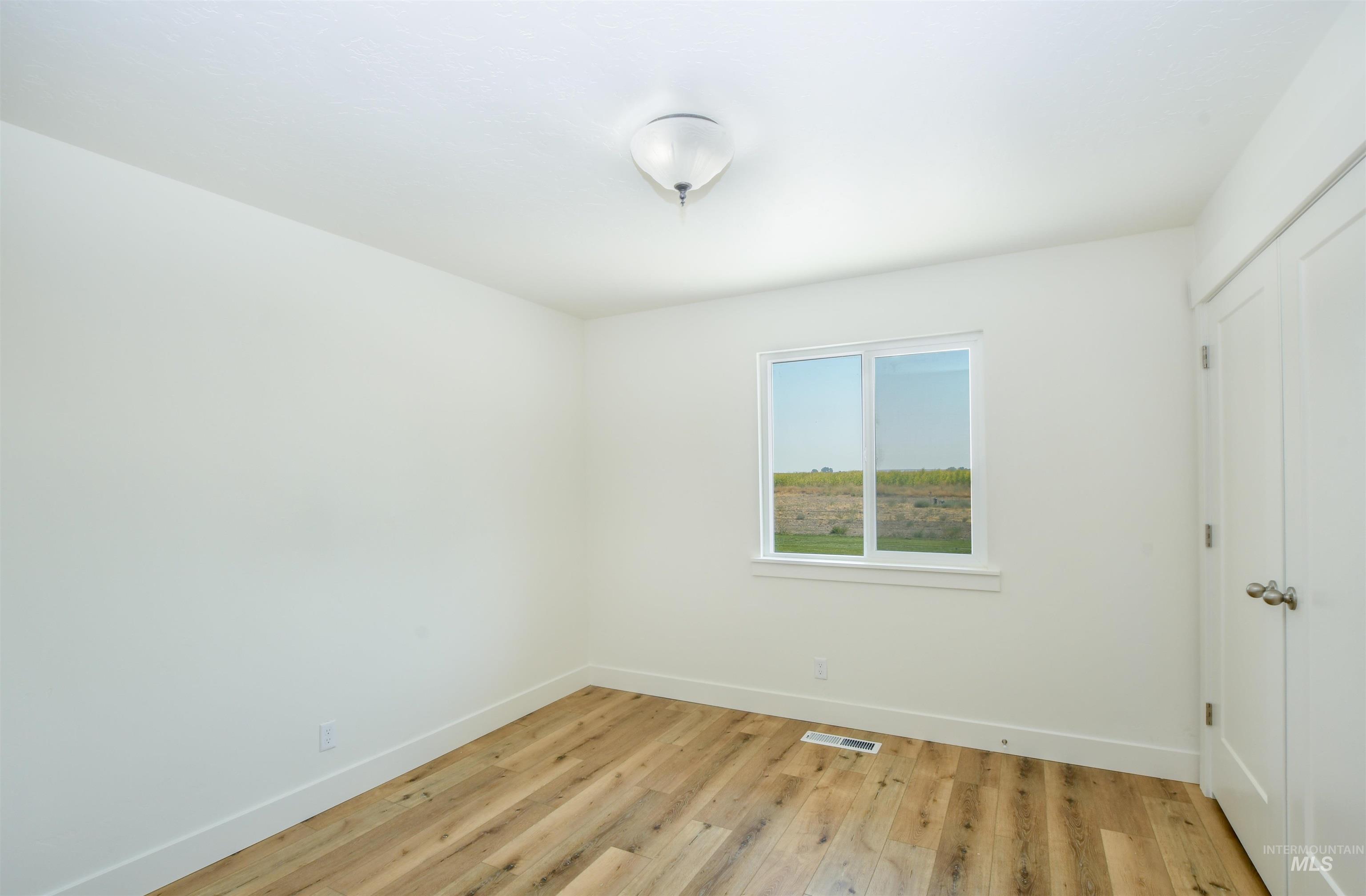 8481 Big Foot Road Melba, ID 83641 - Photo 14 of 41 Empty room with light wood finished floors and baseboards