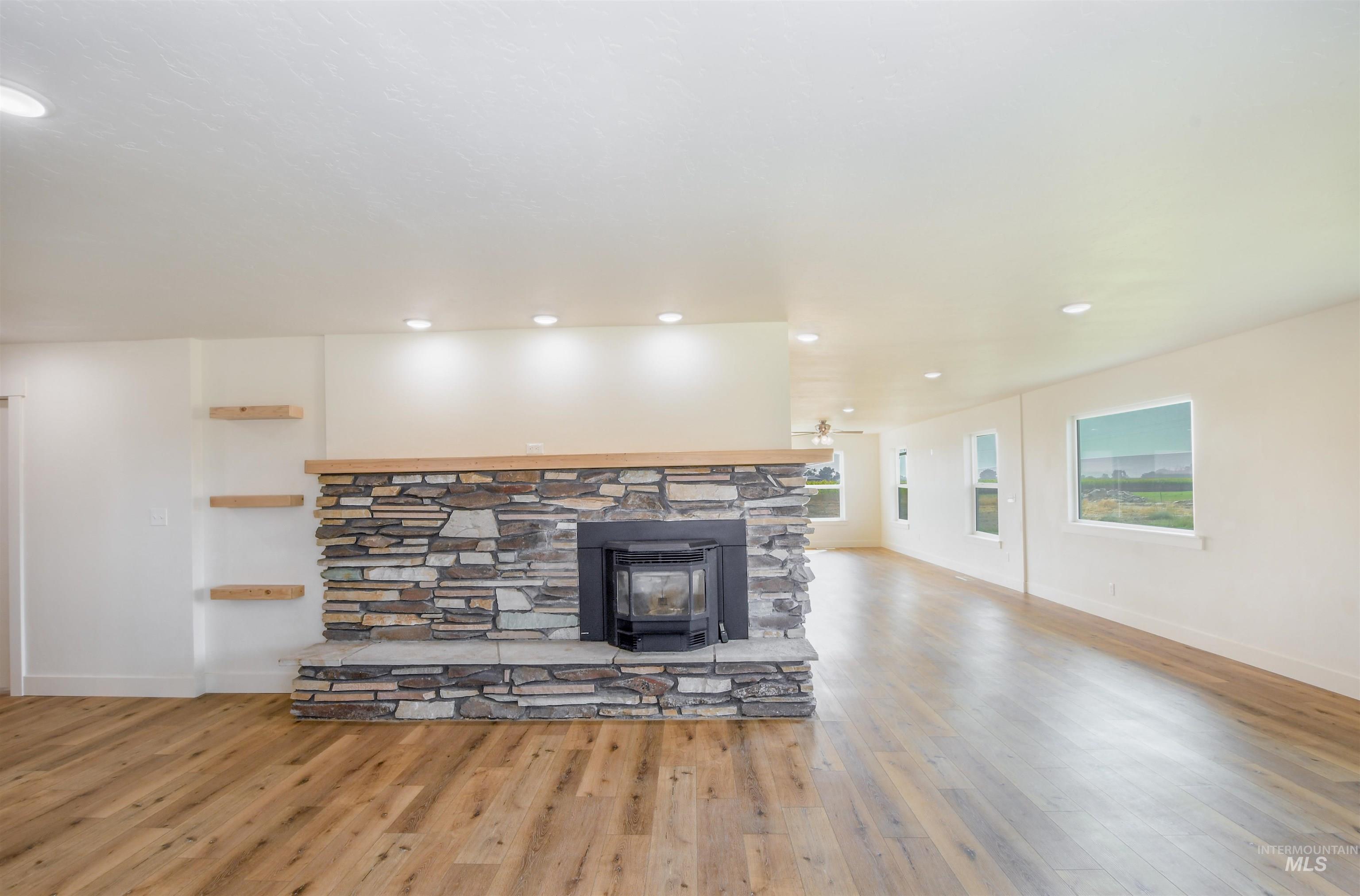 8481 Big Foot Road Melba, ID 83641 - Photo 3 of 41 Unfurnished living room featuring light wood finished floors, recessed lighting, and a wood stove