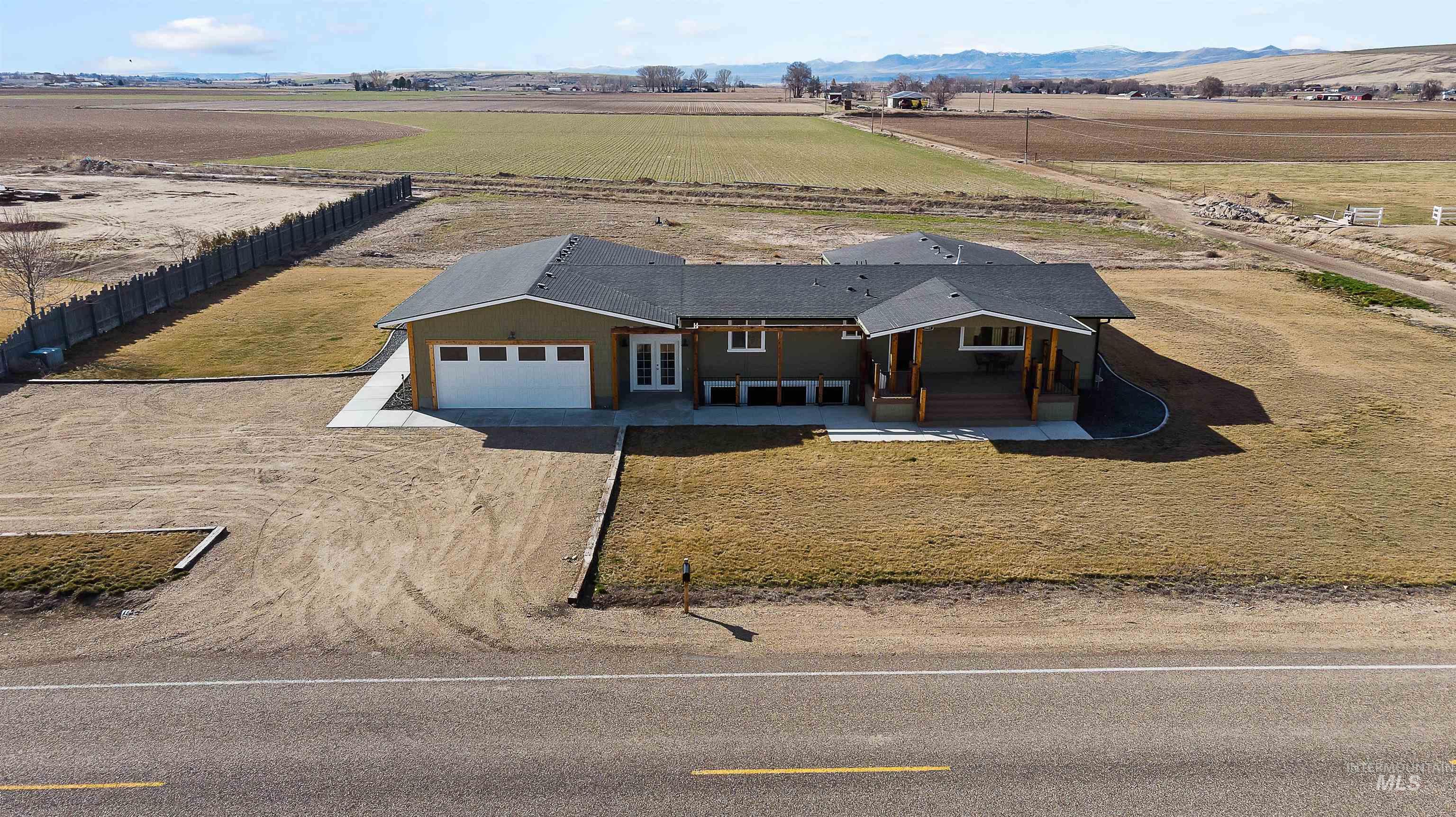 8481 Big Foot Road Melba, ID 83641 - Photo 35 of 41 View of front facade with dirt driveway, a patio, an attached garage, and a view of rural / pastoral area