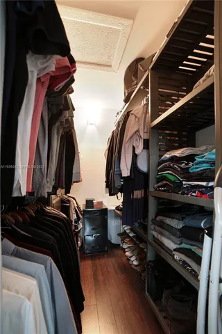 a view of walk in closet with clothes and shoes