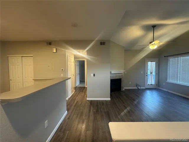 a view of a living room with wooden floor and fireplace