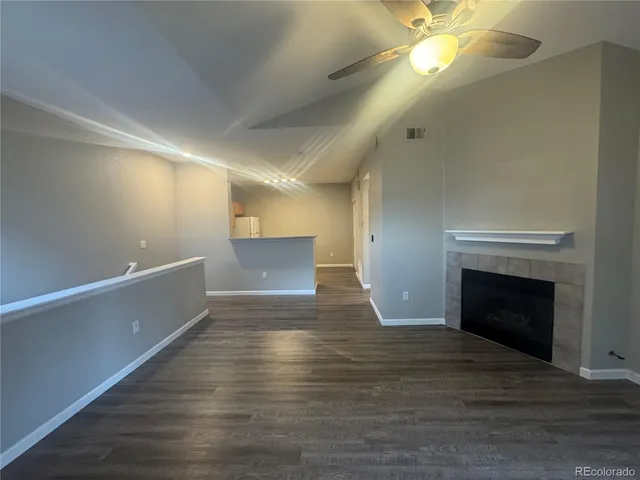 a view of empty room with wooden floor and fireplace