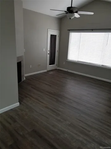 a view of empty room with wooden floor and fireplace