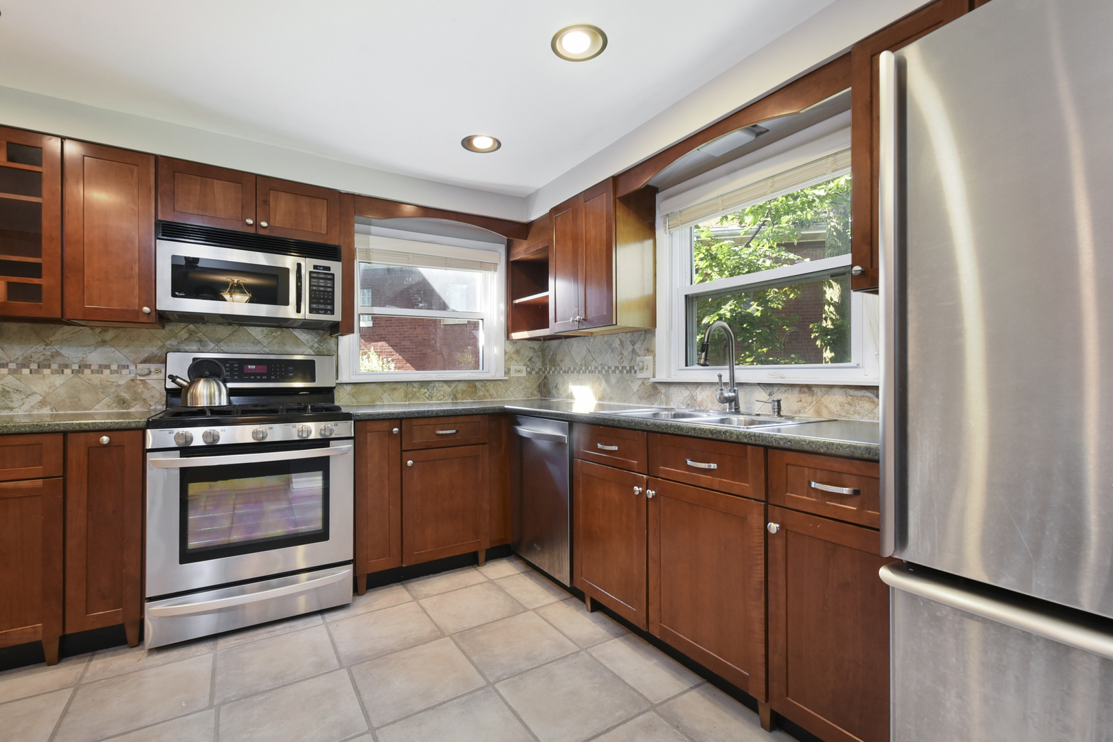 345 Olmsted Road Riverside, IL 60546 - Photo 4 of 31 a kitchen with stainless steel appliances granite countertop a stove sink and microwave