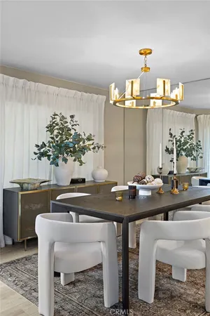 a view of a dining room with furniture a chandelier and wooden floor