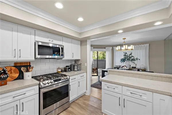 a kitchen that has a lot of cabinets a sink and appliances