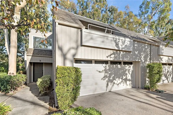 a view of backyard with a table and chairs with a large tree