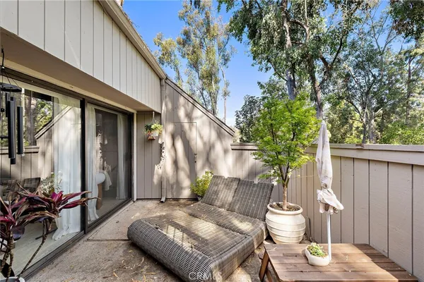 a view of a patio with couple of chairs and a potted plant