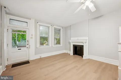 an empty room with windows and fireplace