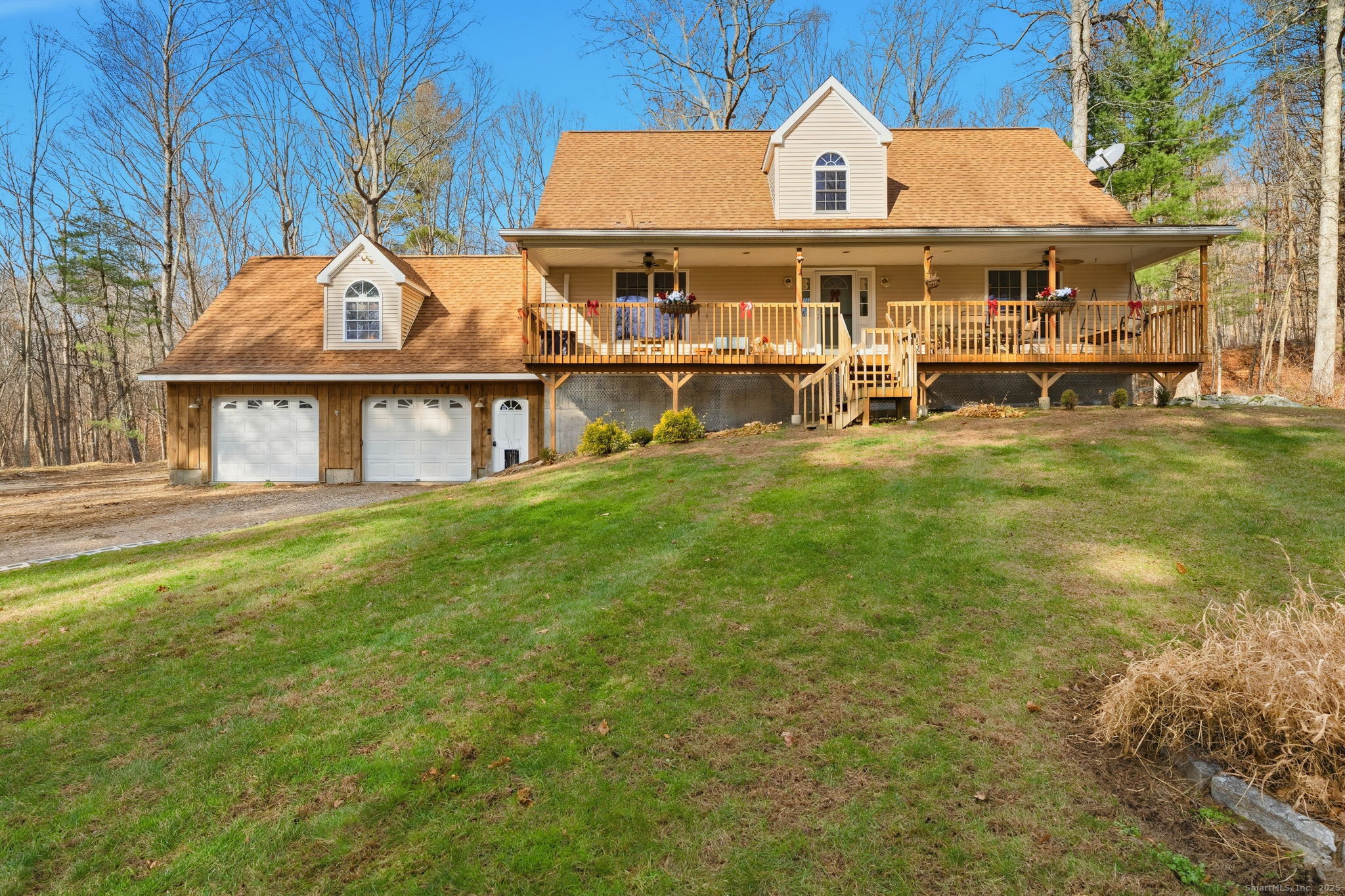 a front view of a house with a garden and lake view