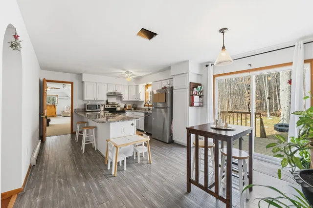a kitchen with a table chairs refrigerator and microwave