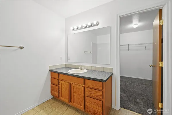a bathroom with a granite countertop sink and a mirror