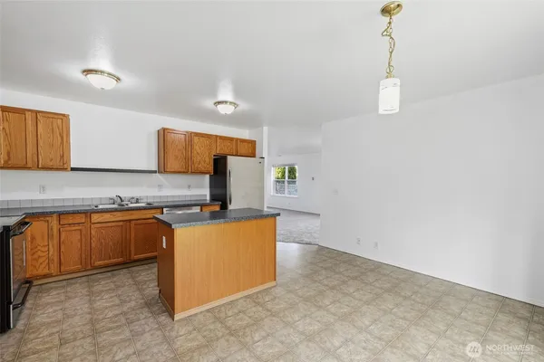 a kitchen with stainless steel appliances granite countertop a sink a stove top oven a counter space and cabinets