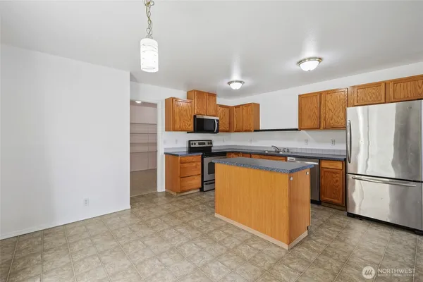 a kitchen with stainless steel appliances granite countertop a refrigerator a stove a sink and a microwave