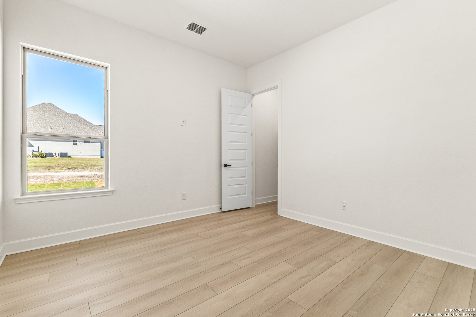 241 Stone Loop Castroville, TX 78009 - Photo 12 of 23 an empty room with wooden floor and windows