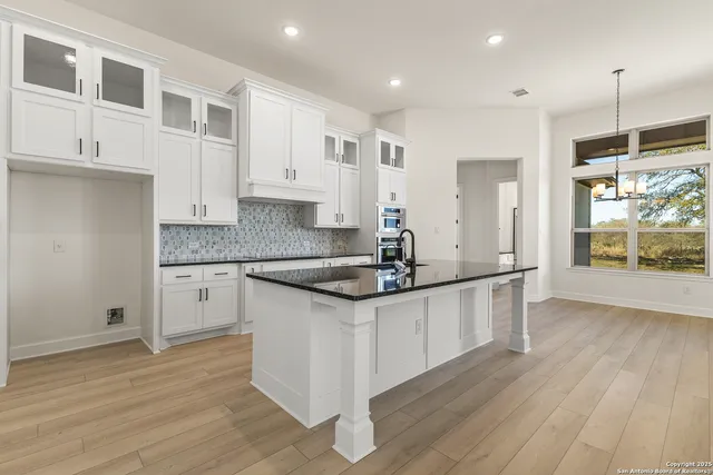a kitchen with stainless steel appliances granite countertop a sink stove and wooden floor