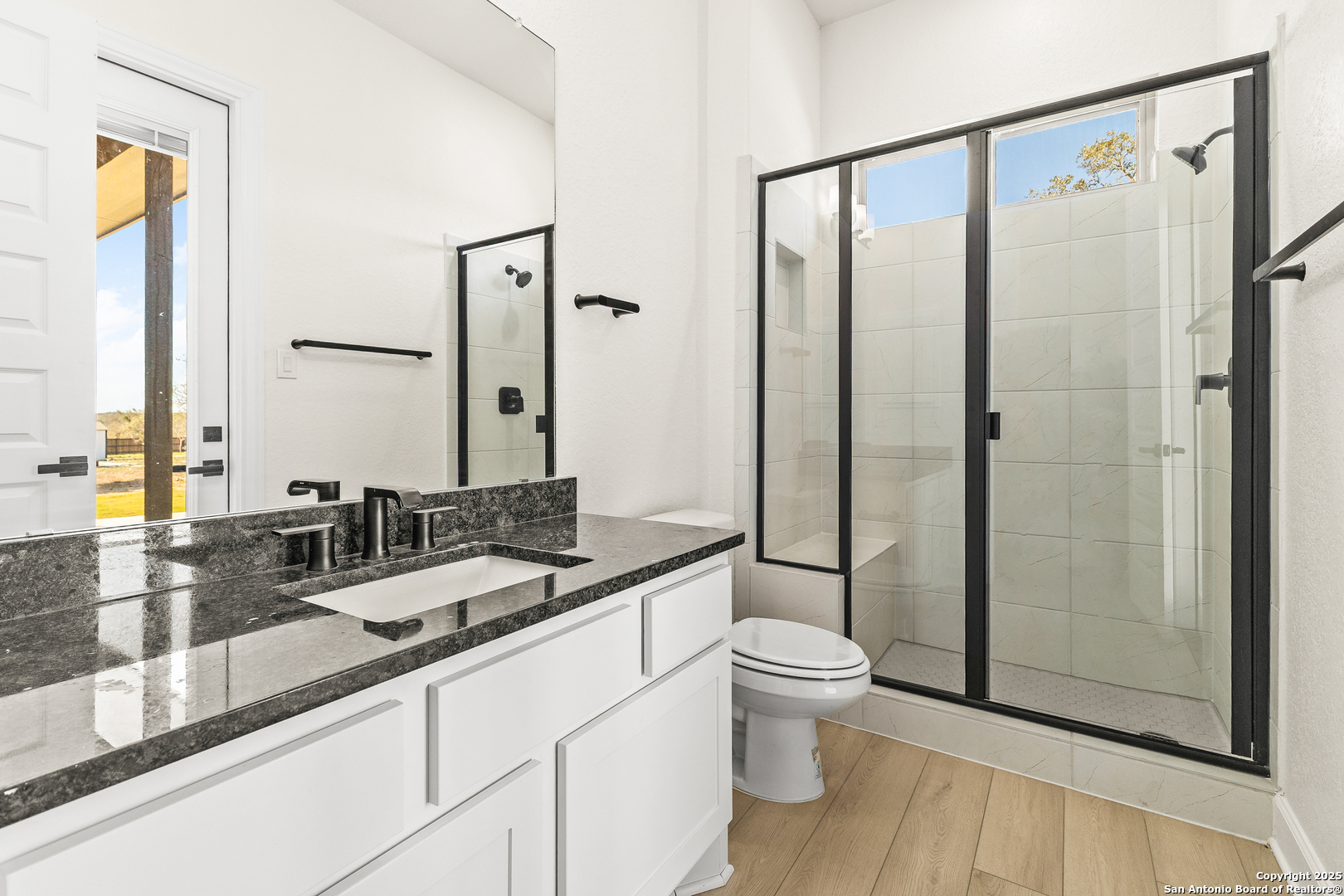 241 Stone Loop Castroville, TX 78009 - Photo 14 of 23 a bathroom with a double vanity sink toilet and shower