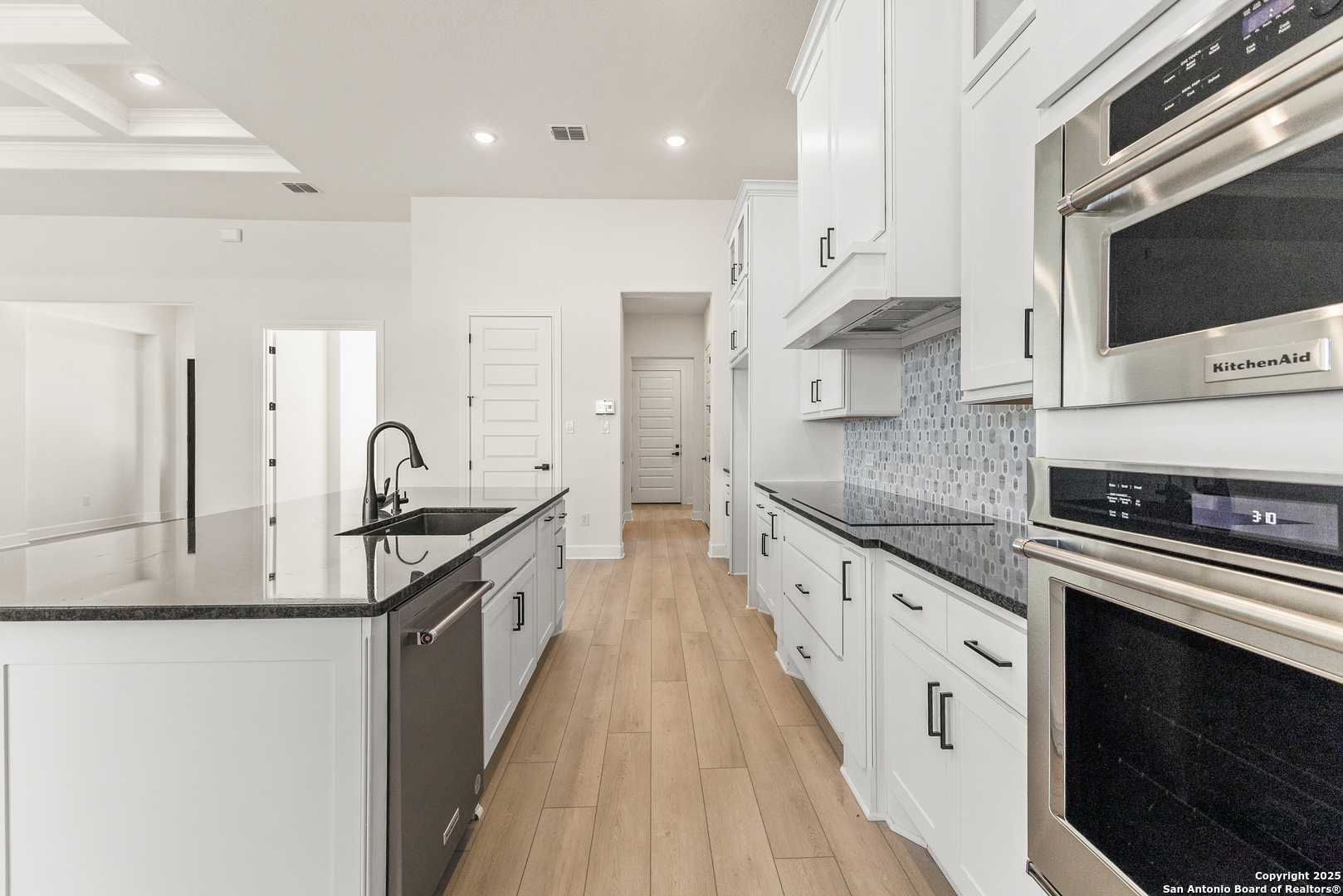 241 Stone Loop Castroville, TX 78009 - Photo 15 of 37 a kitchen with stainless steel appliances granite countertop a stove a sink and a microwave