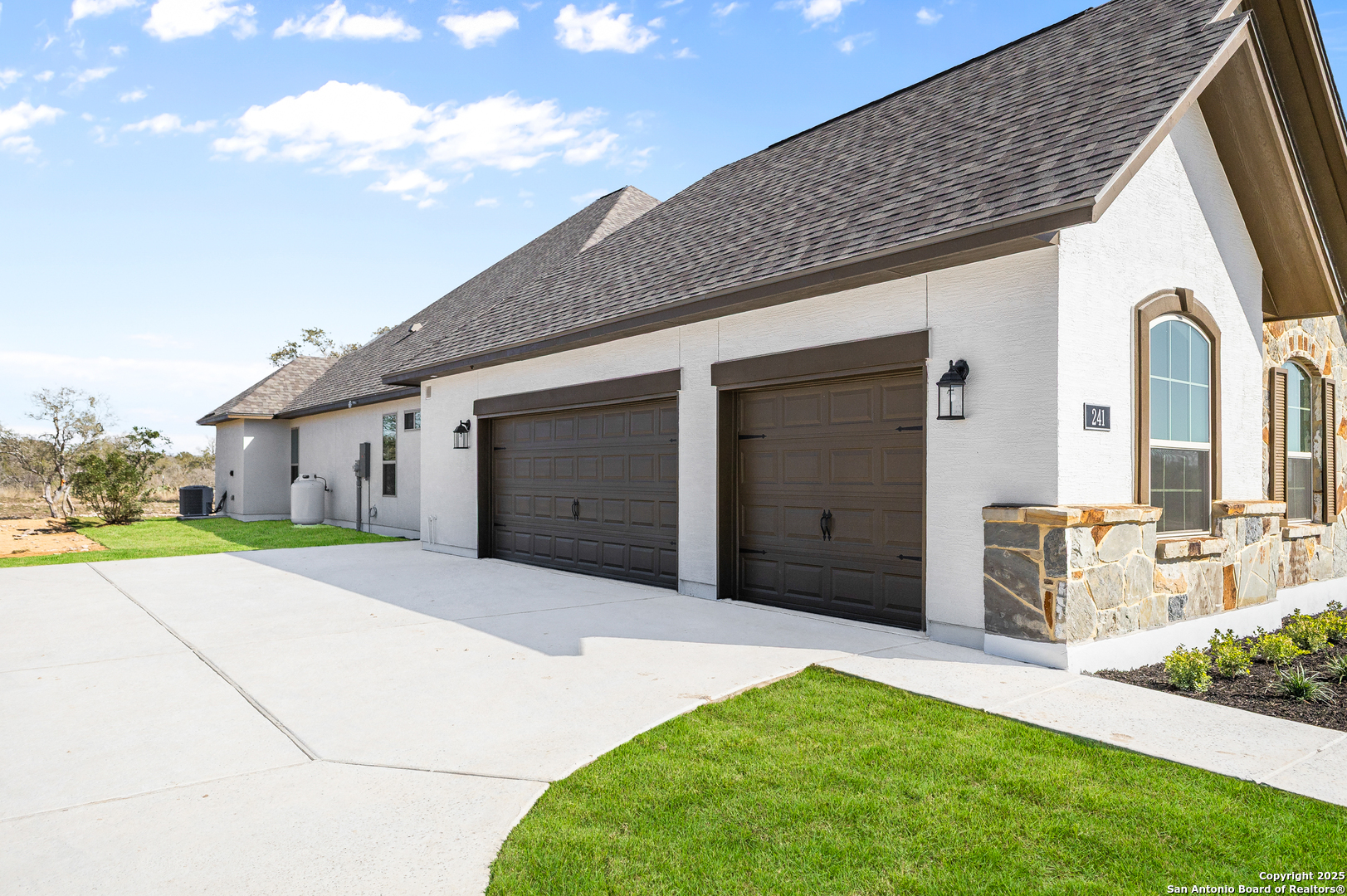 241 Stone Loop Castroville, TX 78009 - Photo 22 of 23 a front view of a house with a garden and yard