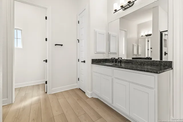 a bathroom with a granite countertop sink and a mirror